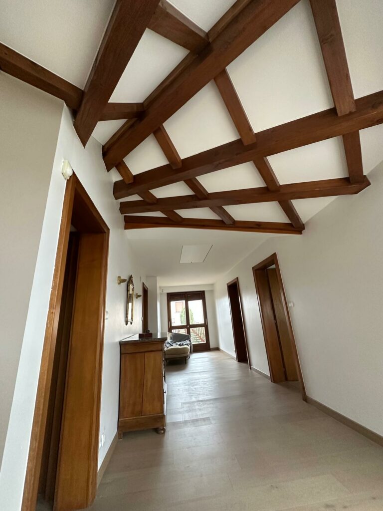 Vue d'un intérieur rénové avec un faux plafond élégant en bois et des cloisons impeccables, illustrant l'expertise d'IS Plâtrerie en Alsace.