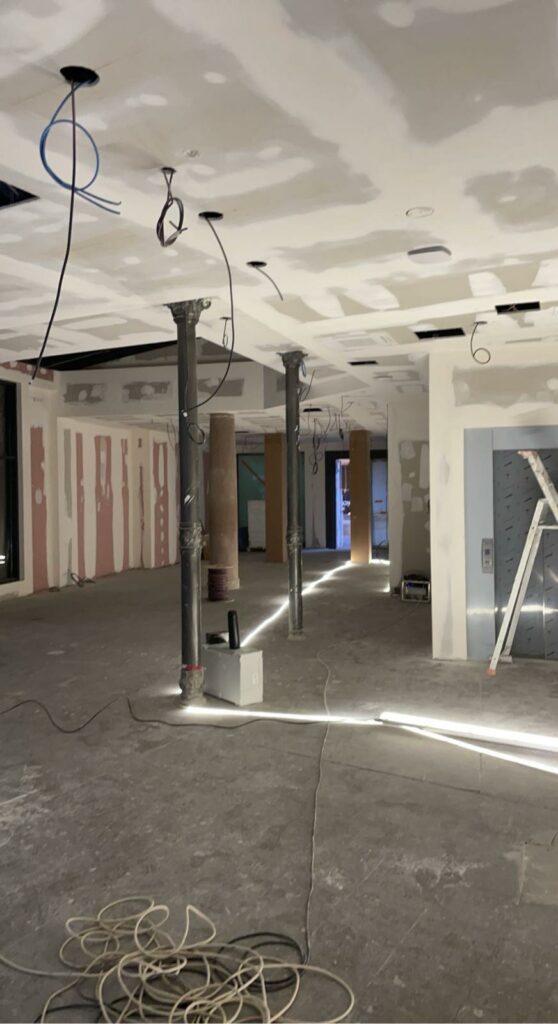 Vue d'un chantier en cours avec des cloisons et un faux plafond en cours de finition, mettant en avant le savoir-faire en cloisons d'IS Plâtrerie.